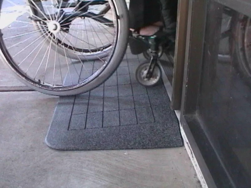 Wheelchair approaching a textured mat at the entrance of a building, EZEdge™ Wheelchair Ramps